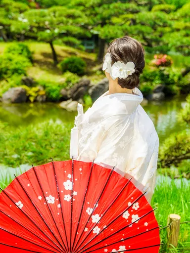 白無垢姿で庭園に佇む女性の後ろ姿