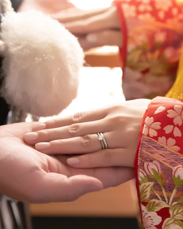 重ねられた夫婦の手と結婚指輪(和装の婚礼にて)